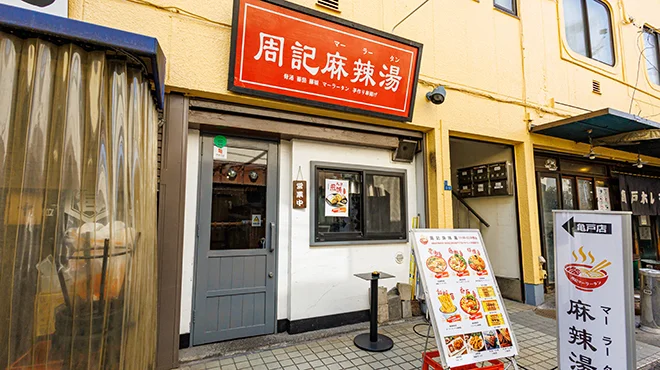 道路に面した飲食店の入口とガラス張りの正面外観