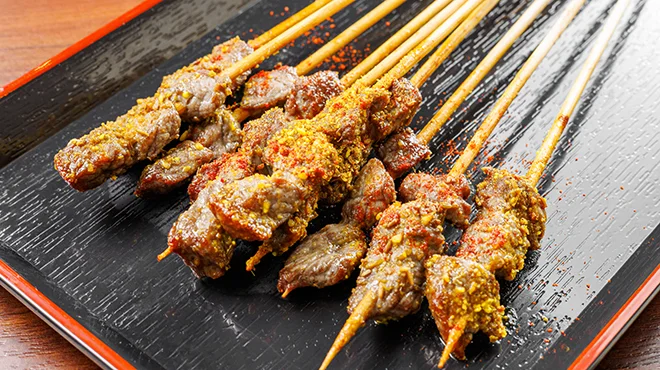焼き色の付いた肉の串焼きを並べた皿